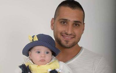 El oficial de policía israelí Zidan Saif sostiene a su pequeña bebé en una foto familiar. Saif fue asesinado mientras cumplía su deber el 18 de noviembre de 2014.
