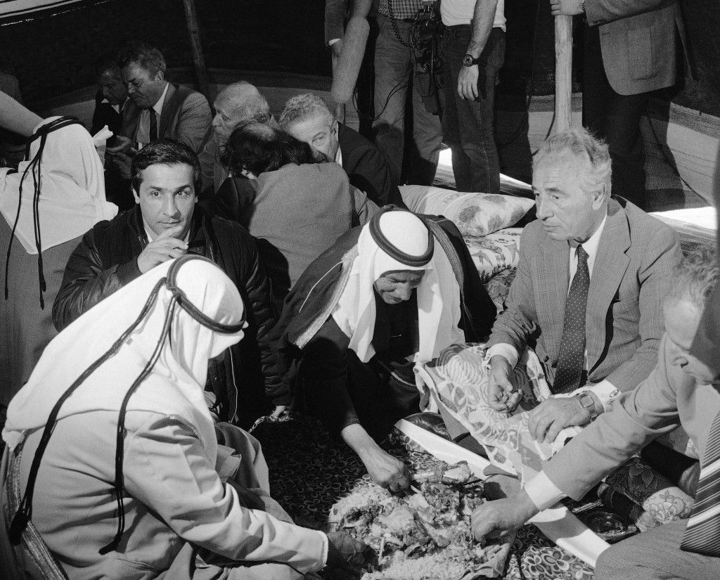 El Primer Ministro Shimon Peres, come con las manos al estilo de los beduinos durante una fiesta del Sheik Ali Abu Rubeia, en K’Seifa, desierto de Negev, en 1985