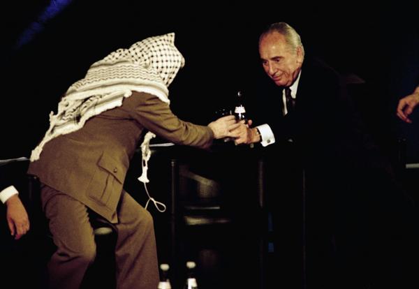 Shimon Peres le sirve agua a al líder palestino Yasser Arafat en un encuentro en la UNESCO sobre Medio Oriente. Paris , 1995 (AP)