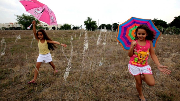 En Ashkelon dos niñas celebran la primera lluvia de la temporada. Foto de Edi Israel/FLASH90. 