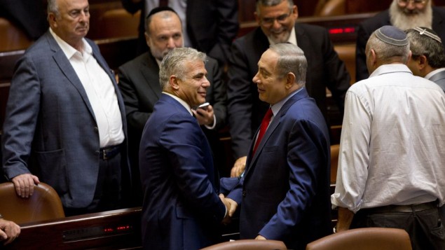 Prime Minister Benjamin Netanyahu shakes hands with Yair Lapid, leader of the Yesh Atid party, during a session at the Knesset, October 31, 2016. (AP Photo/Sebastian Scheiner)