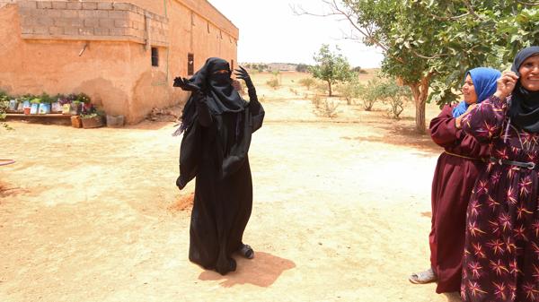 Una mujer de una pequeña aldea cercana a Manbij, al norte de Siria, festeja la expulsión de ISIS sacándose el burka que los yihadistas le impusieron (Reuters)
