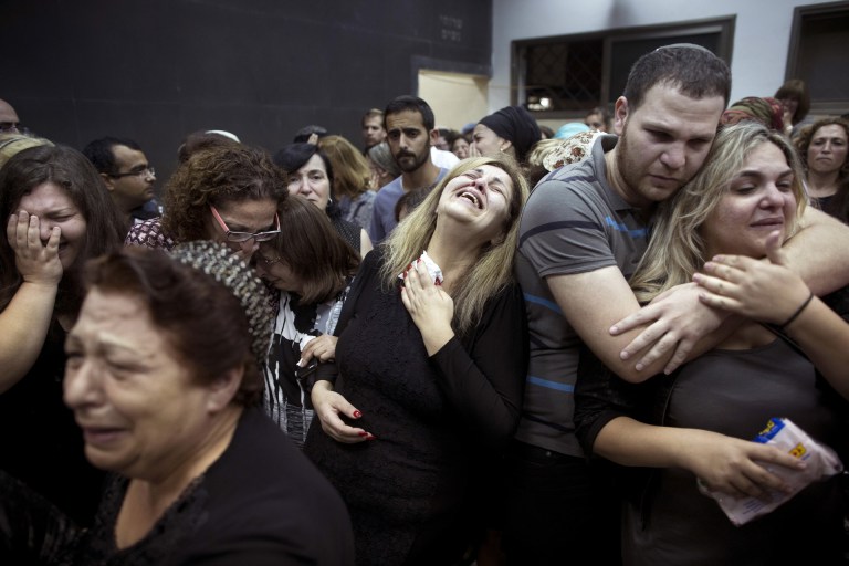 FILE - In this Saturday, June 20, 2015 file photo, friends and relatives of Danny Gonen mourn next to his body during his funeral, at the cemetery in the city of Lod, near Tel Aviv, Israel. Gonen was killed when a gunman opened fire at a car outside a West Bank settlement on Friday, killing an Israeli man and wounding another in what police said was a "terror attack." The Palestinian militant group Hamas praised the attack but stopped short of claiming responsibility. (AP Photo/Oded Balilty, File)